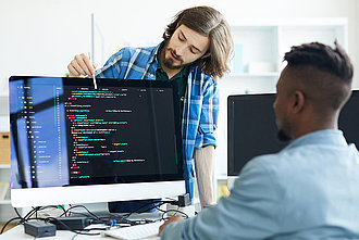 Zwei Männer schauen in einen PC